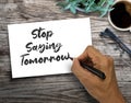 Text sign showing Stop Saying Tomorrow. on wood table