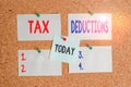 Text sign showing Tax Deductions. Conceptual photo an amount or cost that subtracted from someone s is income Corkboard Royalty Free Stock Photo