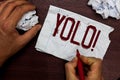 Text sign showing Yolo. Conceptual photo stand for You only live once popular phase among students and teens Man holding
