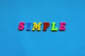 text simple from plastic colored letters on blue paper background.