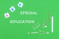 Text special education, from above wooden minitures school supplies and abc letters on green background