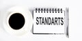 Text STANDARTS , planning concept. notebook with text on white background with coffee