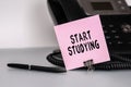 The text Start Studying written on a pink sticky note to remind you an important event. Closeup of a personal agenda Royalty Free Stock Photo