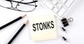 Text STONKS on the sticker with keyboard , pencils and office tools Royalty Free Stock Photo