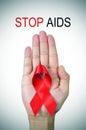 Text stop AIDS and a red ribbon in a man hand Royalty Free Stock Photo