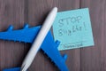 Text Stop flights Coronavirus on sticky note and airplane model on wooden background