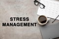 Text Stress Management on grey table with calendar, stationery, eyeglasses and cup of coffee, flat lay Royalty Free Stock Photo