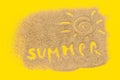 Text Summer And Sun Sign Drawn On Sand On Yellow Paper Background. Creative Top View Concept Vacation