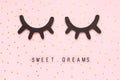 Text Sweet dreams and decorative wooden black eyelashes, closed eyes gold star on pink paper background. Concept Good Royalty Free Stock Photo