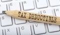 Text TAX DEDUCTIBLE on wooden pencil on white keyboard. Business concept