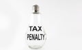 Text TAX PENALTY on the bulb on the white background. Business concept Royalty Free Stock Photo