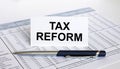 Text Tax Reform on white card with blue metal pen on financial table Royalty Free Stock Photo