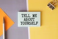 text TELL ME ABOUT YOURSELF on white noteboock. Royalty Free Stock Photo