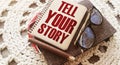 Text Tell Your Story on the cover of book, glasses and pen. Business concept for Storytelling Telling Story written on notepad