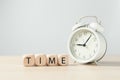 Text `Time` on wooden blocks cube with alarm clock. Royalty Free Stock Photo