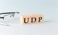 Text UDP - User Datagram Protocol written on the wooden cubes on blue background
