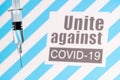 Text Unite against COVID-19 with glass syringe on blue background. Concept about vaccine of coronavirus or COVID-19 Royalty Free Stock Photo