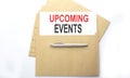 Text UPCOMING EVENTS on paper on envelop on white background