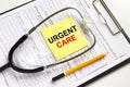 Text Urgent Care on a yellow sticker with a stethoscope lying on a folder with medical documents