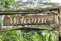 Text welcome on a wooden board in a rainforest jungle of tropical Bali island, Indonesia. Welcome wooden sign inscription in the