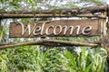 Text welcome on a wooden board in a rainforest jungle of tropical Bali island, Indonesia. Welcome wooden sign inscription in the Royalty Free Stock Photo
