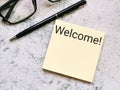Text Welcome written on sticky note with a pen and eye glasses. Royalty Free Stock Photo