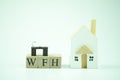 Text of WFH mean work from home with miniature table and wood home Royalty Free Stock Photo