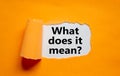 The text `what does it mean` appearing behind torn orange paper. Business concept, copy space Royalty Free Stock Photo