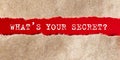 The text WHAT S YOUR SECRET . behind torn paper on red background Royalty Free Stock Photo
