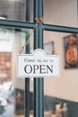 White sign OPEN hanging in cafe front door