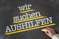 Text WIR SUCHEN AUSHILFEN, German for Help Wanted, written on blackboard Royalty Free Stock Photo