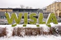 The text WISLA of this Polish city made from green bush in snowy winter