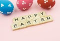 Text wooden blocks spelling the word happy easter on pink background Royalty Free Stock Photo