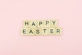 Text wooden blocks spelling the word happy easter on pink background Royalty Free Stock Photo