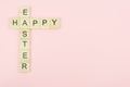 Text wooden blocks spelling the word happy easter on pink background Royalty Free Stock Photo