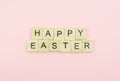 Text wooden blocks spelling the word happy easter on pink background Royalty Free Stock Photo