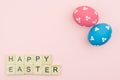 Text wooden blocks spelling the word happy easter on pink background Royalty Free Stock Photo