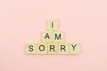 Text wooden blocks spelling the word I am sorry on pink background Royalty Free Stock Photo