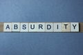 Text the word absurdity from brown wooden small letters