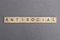 Text the word antisocial from wooden small letters