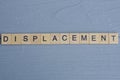 text the word displacement from brown wooden small letters