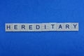 The text of the word hereditary from small gray wooden letters