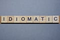 Text the word idiomatic from brown wooden small letters