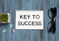 the word Key To Success, is written in a notebook lying on white table with a pen, glasses and magnifier. Business Royalty Free Stock Photo