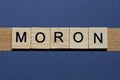 Text the word moron from brown wooden small letters