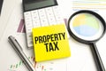 Text, the word Property Tax is written in a notebook lying on a black table with a pen, glasses and a calculator. Business concept Royalty Free Stock Photo