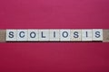 text the word scoliosis from gray wooden small letters