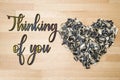 Thinking of you - card. Heart lined with husks of sunflower seeds on a background of beech wood. Royalty Free Stock Photo