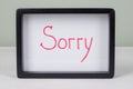 Text word SORRY, black frame, on white table. Royalty Free Stock Photo