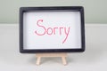 Text word SORRY, black frame, on white table. Royalty Free Stock Photo